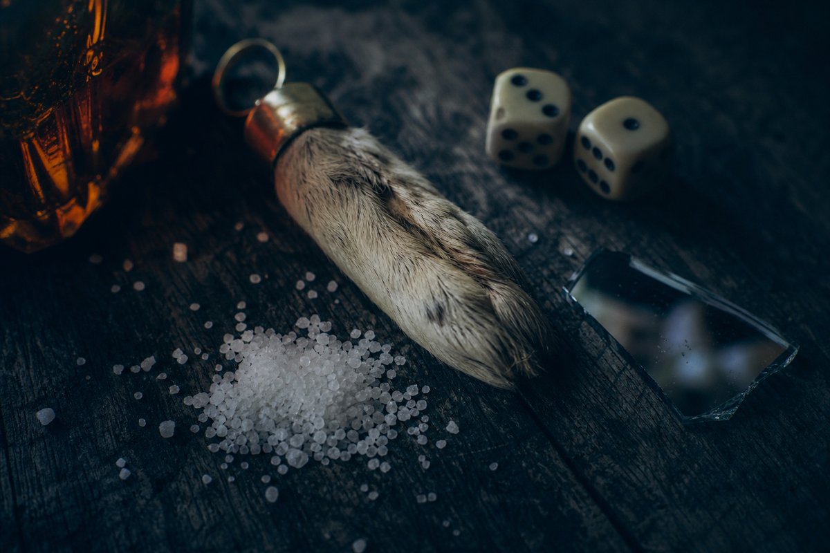 Glücksbringer, verschüttetes Salz und Würfel auf dunklem Holz